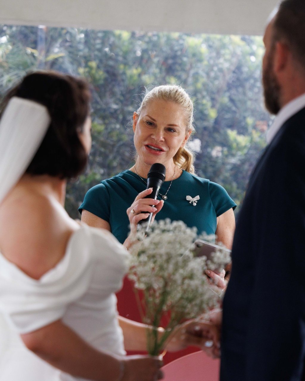 Nicole Webster smiling as she leads a garden marquee wedding ceremony in Sydney