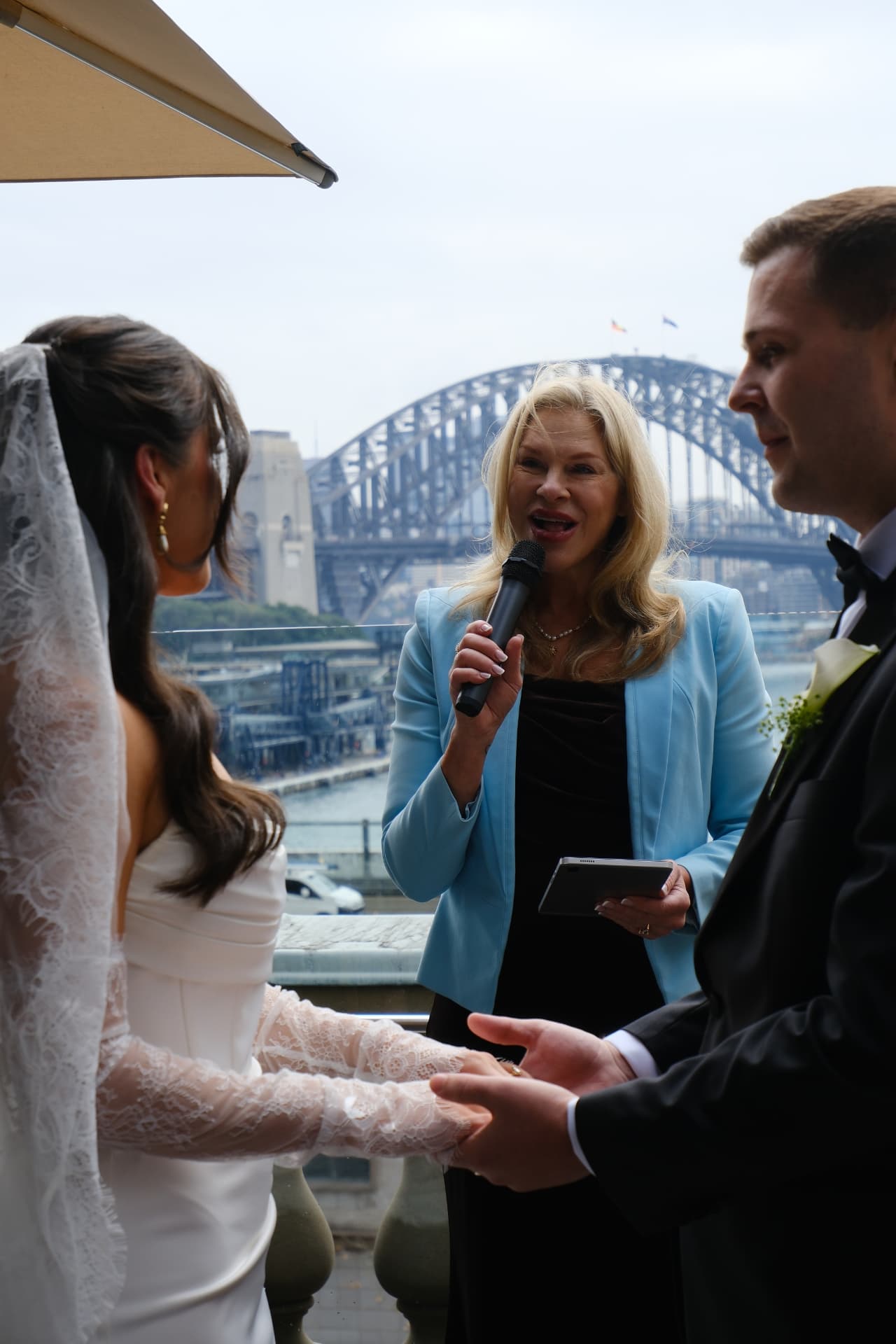 Hands held through the vows, Harbour Bridge beyond