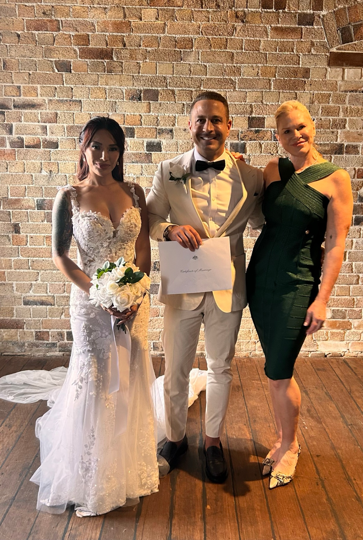 Nicole with newlyweds and their marriage certificate