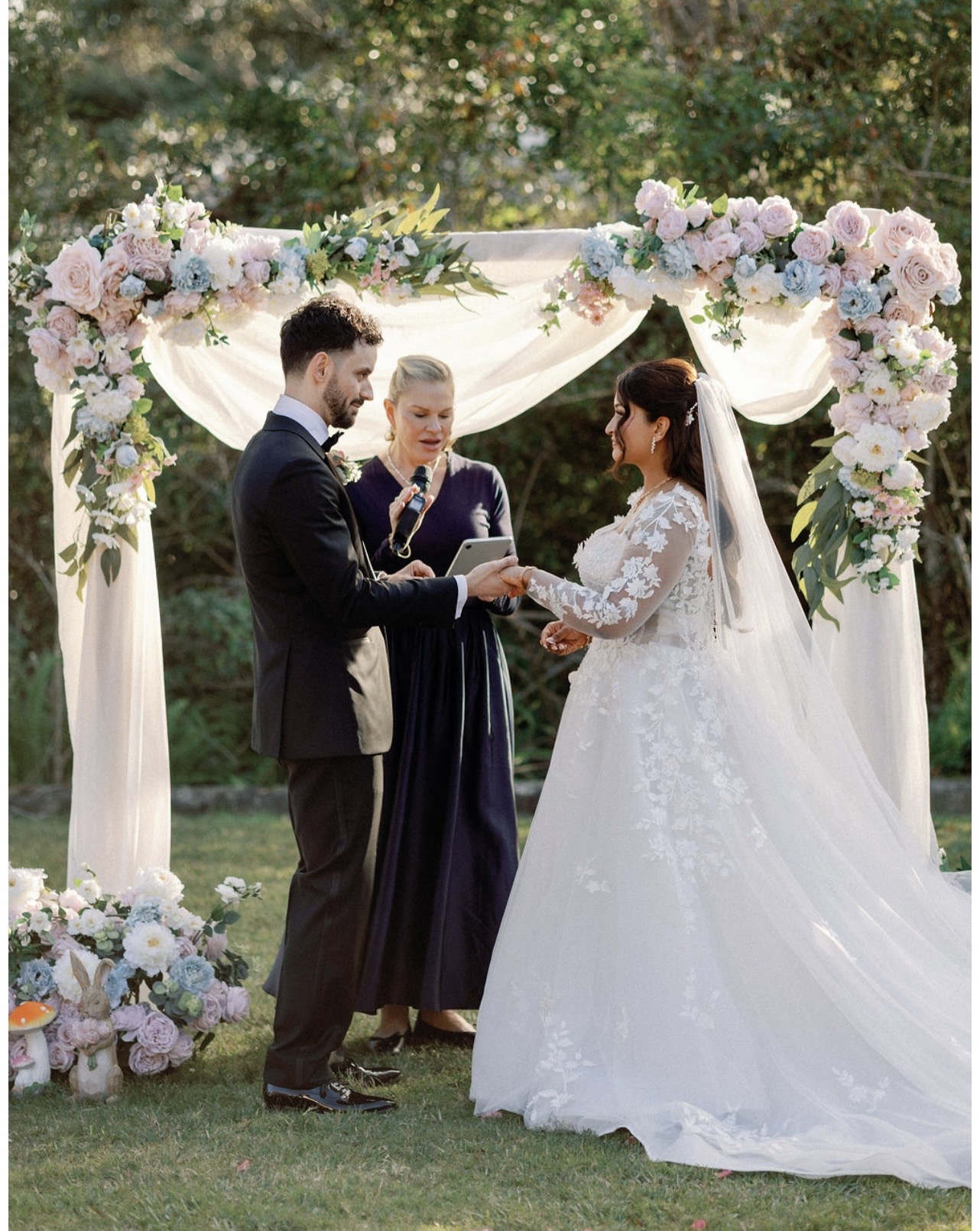 Vows beneath a pastel floral arch