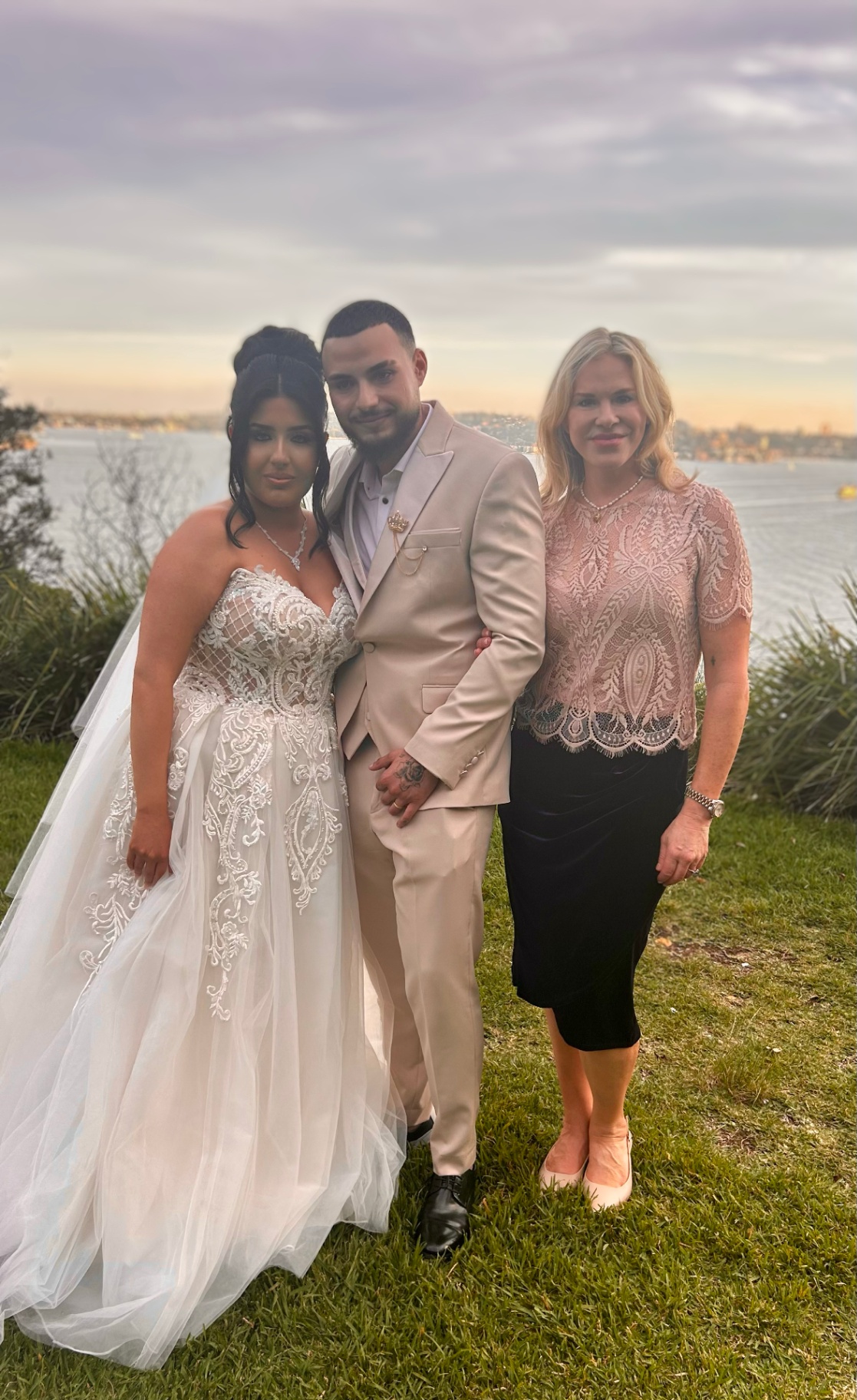 Nicole with newlyweds beside the water at dusk
