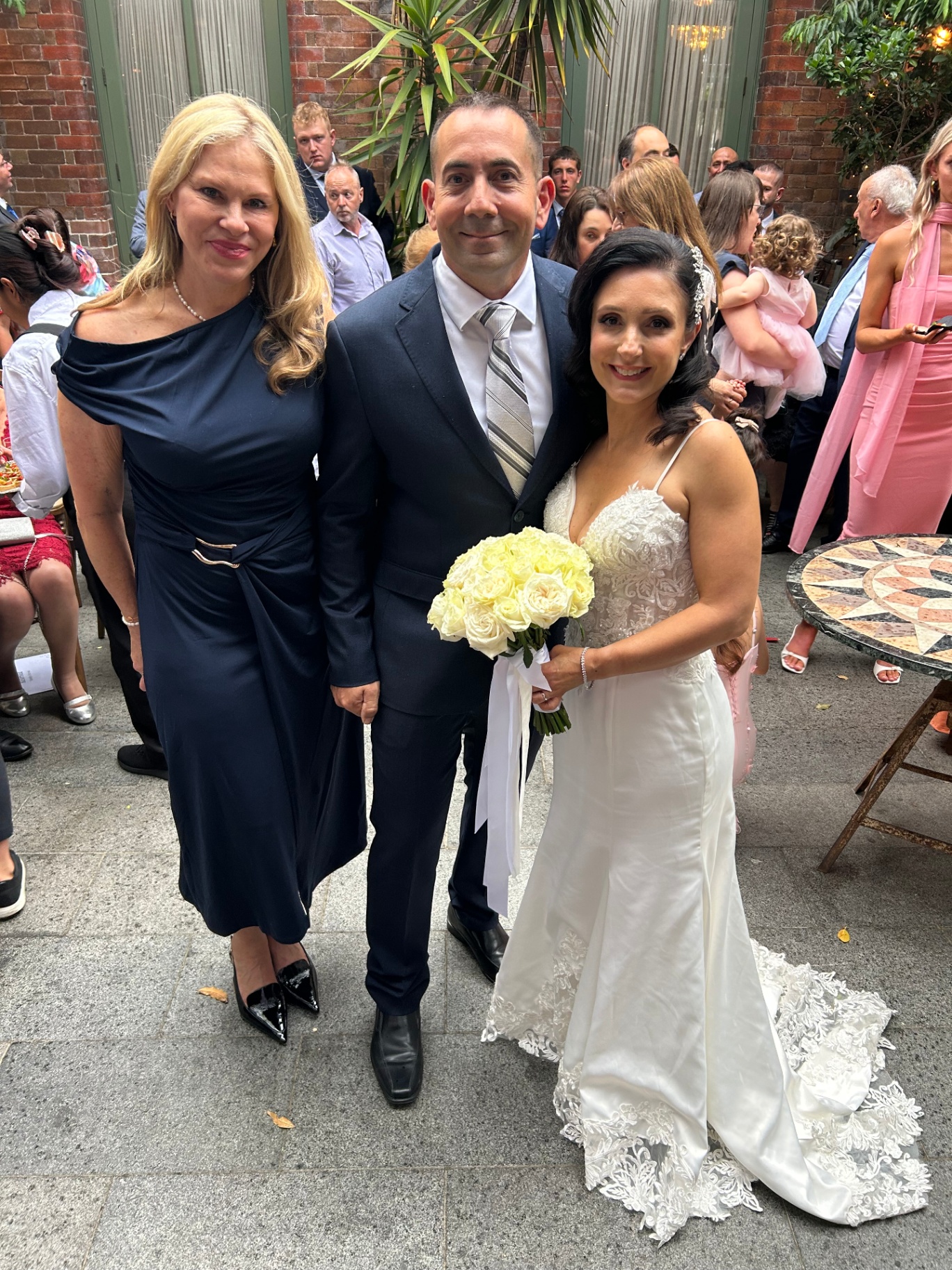 Nicole with newlyweds at their courtyard celebration