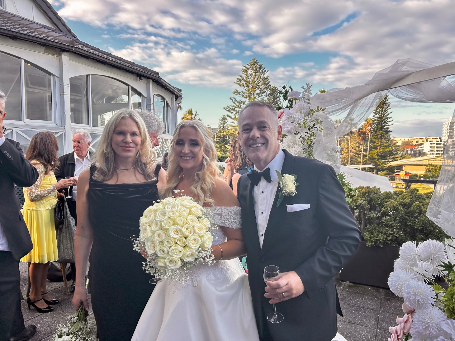 Nicole with newlyweds on a sunlit harbour terrace